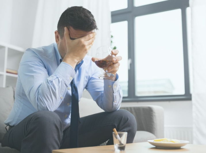 мужчина с бокалом закрыл лицо рукой